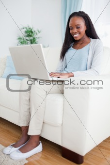 Woman on couch looking at computer screen