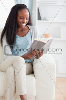 Woman reading a book on her sofa