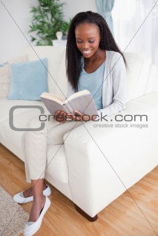 Woman on sofa reading a book