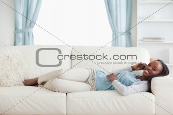 Woman lying on couch with cellphone
