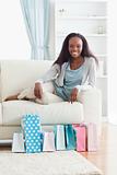 Woman on couch with shopping in front of her