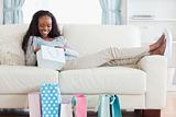 Woman on couch checking her shopping