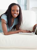 Close up of woman lying on the sofa with her laptop