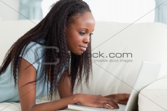 Close up of woman lying on the sofa with her notebook