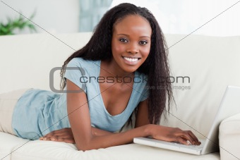 Woman lying on the sofa with her notebook