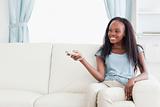 Woman on sofa changing TV programme