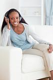 Woman leaning against armrest while listening to music