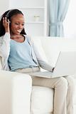 Woman listening to music while using her laptop