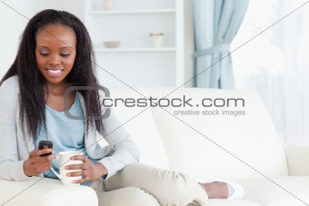 Woman texting while having a coffee