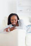 Woman relaxing on couch while texting