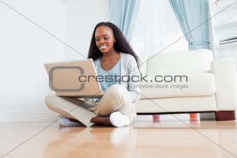 Woman sitting on the floor using her notebook