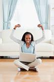Woman stretching while sitting on the floor with laptop