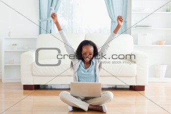 Woman stretching while sitting on the floor working on notebook