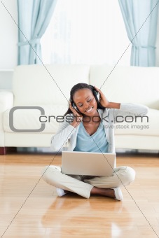Woman sitting on floor listening to music
