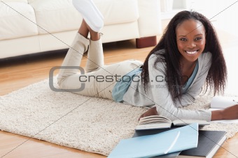 Woman lying on the floor doing her homework