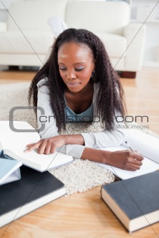 Woman lying on the carpet studying