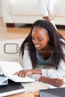 Woman lying on the floor working on a book review