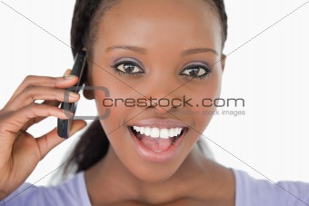 Close up of surprised looking woman on the phone on white background