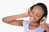 Close up of woman listening to music against a white background