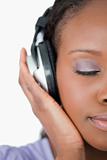 Close up of woman enjoying music against a white background