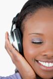 Close up of young woman listening to music on white background