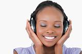 Close up of young woman listening to music with headphones on white background