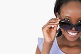 Close up of woman looking over her sunglasses on white background