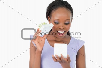 Close up of woman being happy about what is in her present against a white background