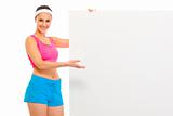 Happy fitness girl in sportswear holding blank billboard

