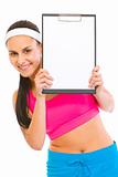 Smiling fit girl looking from blank clipboard
