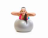 Smiling fit girl making exercise on fitness ball
