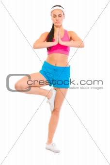 Full length portrait of fitness girl in yoga pose
