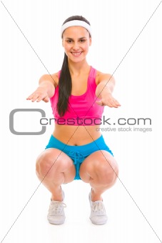 Fitness girl making squat exercise
