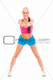 Full lenght portrait of smiling fitness woman doing gymnastics excersice
