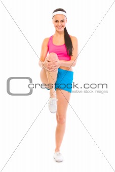 Full lenght portrait of smiling fitness woman doing stretching excersice
