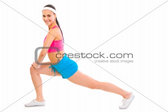 Full lenght portrait of smiling fitness female doing stretching excersice
