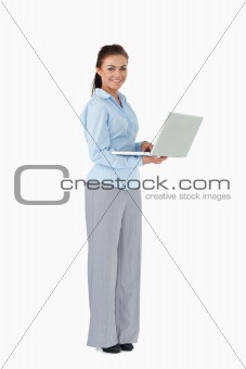 Smiling businesswoman with her laptop against a white background