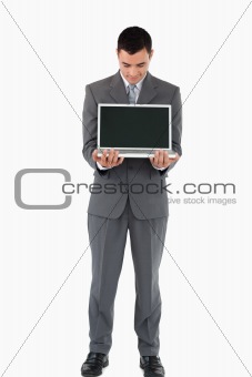 Businessman standing with his laptop against a white background