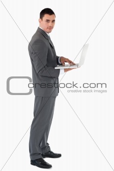 Confident businessman with laptop against a white background