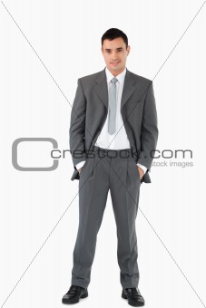 Businessman with his hands in his pockets against a white background