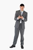 Businessman holding his cellphone against a white background
