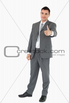 Young businessman giving thumb up