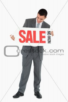 Businessman looking at signboard in his hands