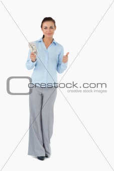 Businesswoman with banknotes giving thumb up