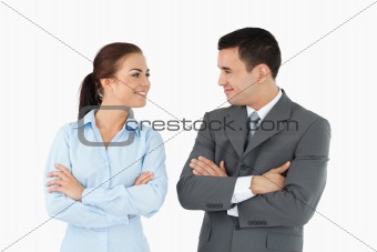 Business partners with arms folded looking at each other