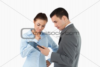 Business partners analyzing document on the clipboard