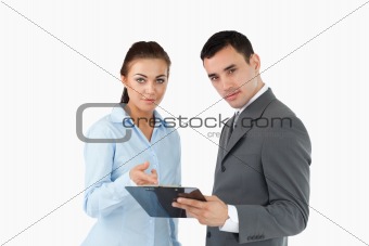 Business partners analyzing data on clipboard