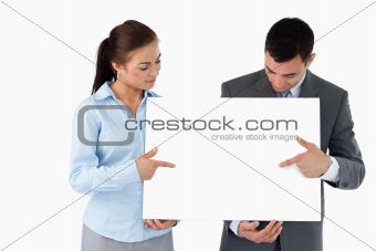Business partners pointing at sign they are presenting