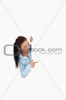 Businesswoman looking around the corner while pointing