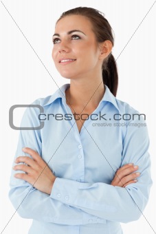 Businesswoman looking diagonally upwards with arms folded